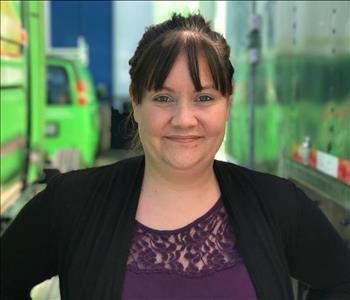 a woman in a purple shirt and black cardigan