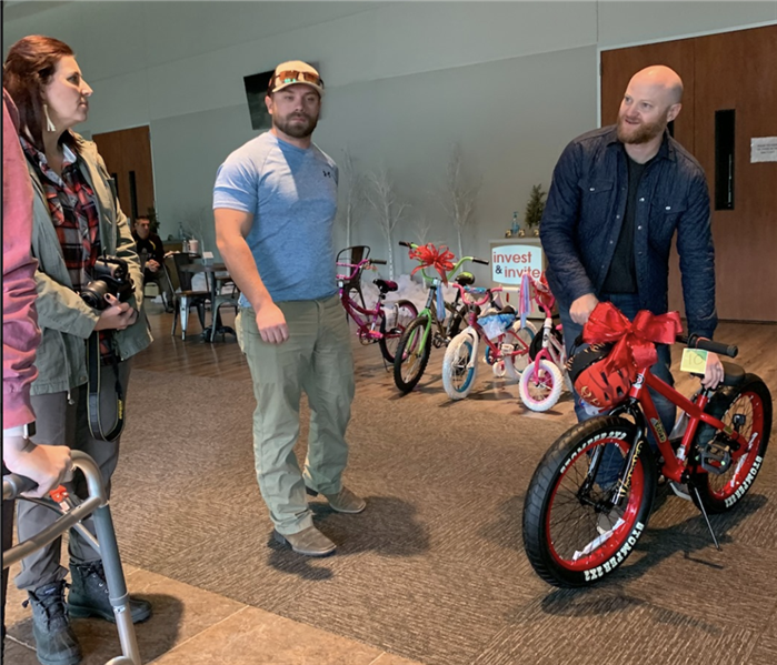 People standing by bikes to be donated.