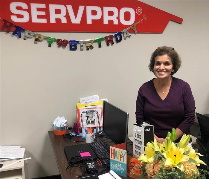 Jean Foty smiling in front of SERVPRO logo.