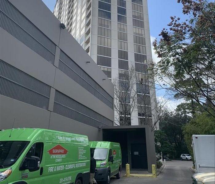 green vans surrounding a high rise building